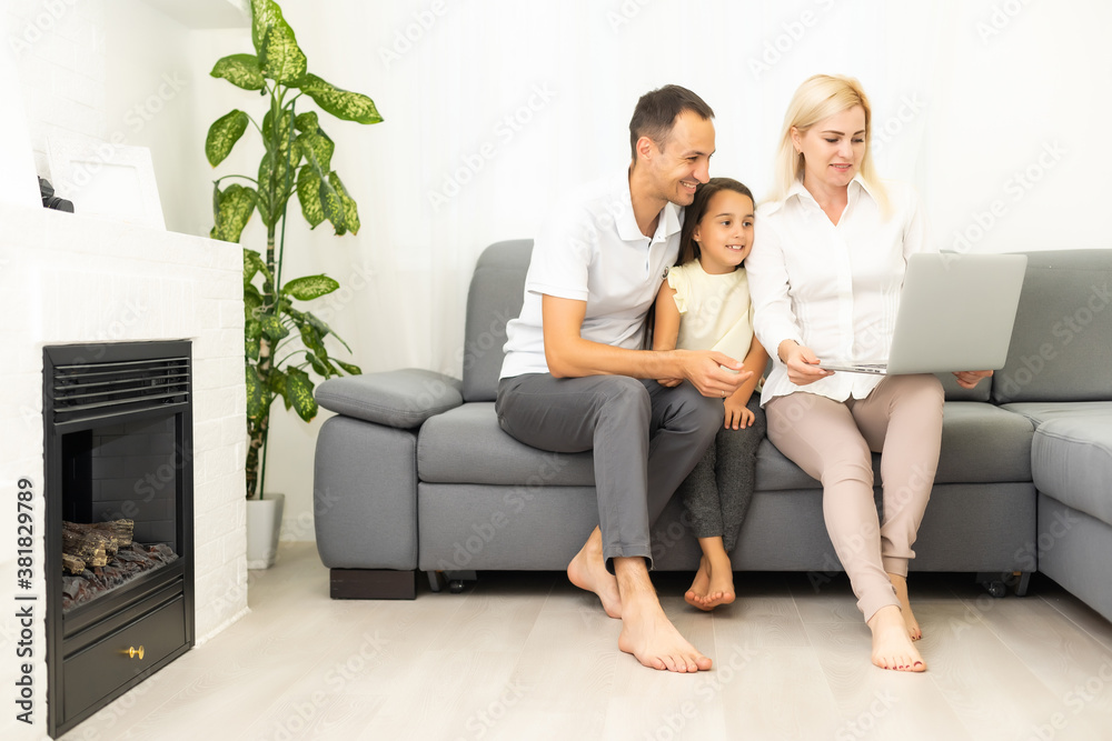 Family shopping online. Happy family smiling while sitting on the couch and shopping online together Family shopping online. Happy family smiling while sitting on the couch and shopping online together