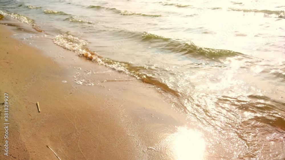 Yellow sand on the banks of a river or lake. Waves roll onto the shore. Yellow sand on the banks of a river or lake. Waves roll onto the shore.