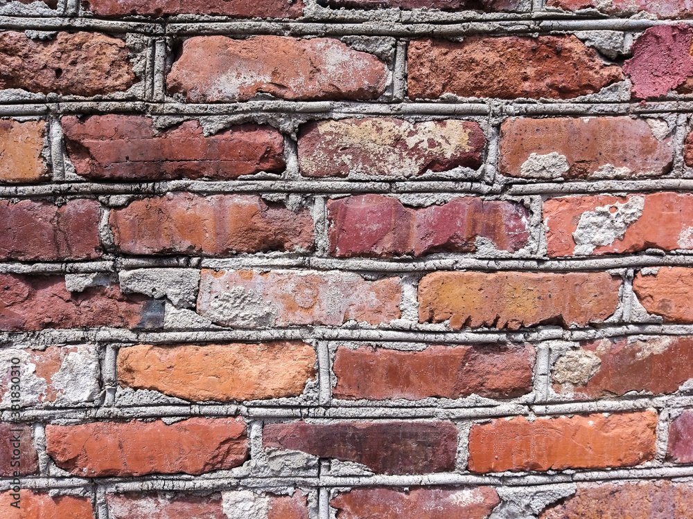 Obraz premium A mottled red brick wall