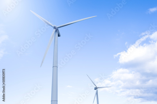 Alternative Energy Concepts. Two Windmills Outdoors Against Blue Sky.