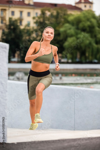 Portrait of Caucasian Female Runner In Professional Outfit During Her Regular Training Exercises Outdoor. © danmorgan12