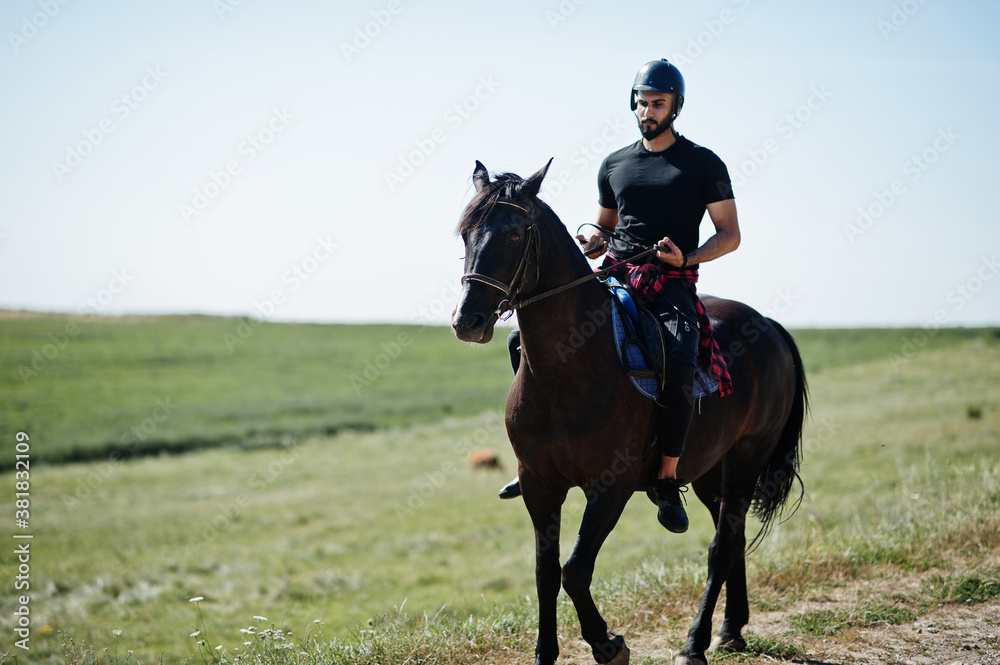 Arab tall beard man wear in black helmet, ride arabian horse.