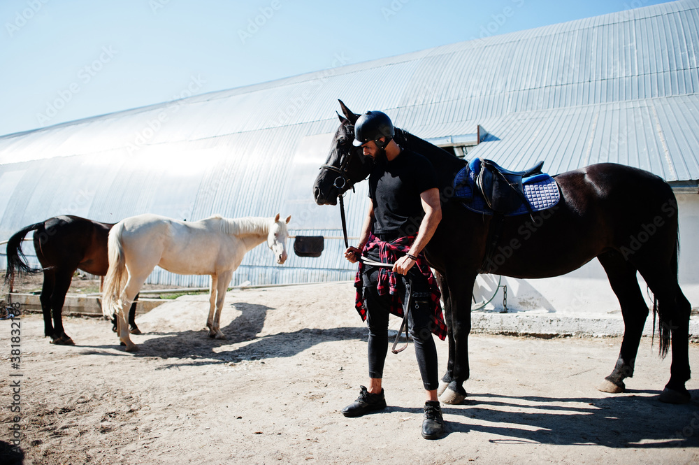 Arab tall beard man wear in black helmet with arabian horse. Arab tall beard man wear in black helmet with arabian horse.
