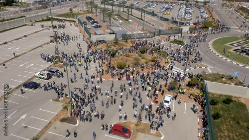 Aerial circling view of people evacuating workplace after fire warning