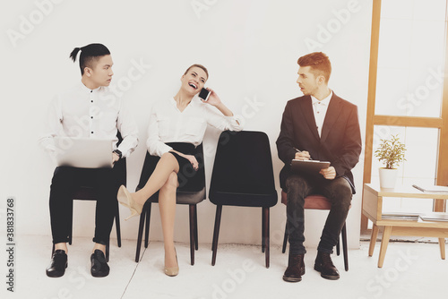 Woman laughs and speaks on phone while sitting.