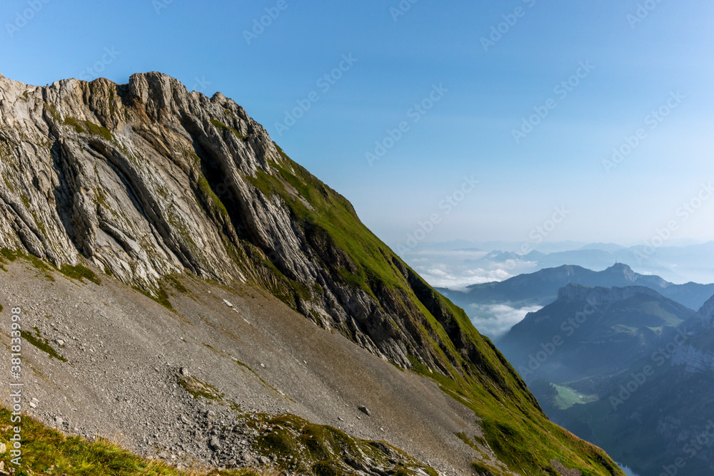 The Alpstein mountain range in Appenzell, Switzerland with the fog in the valley and the view of the Seealpsee lake The Alpstein mountain range in Appenzell, Switzerland with the fog in the valley and the view of the Seealpsee lake