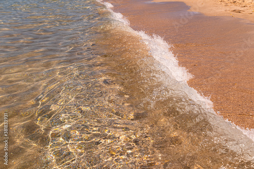 Fototapeta Naklejka Na Ścianę i Meble -  Calm wave of the sea on a golden sandy beach. Seaside holidays and vacations