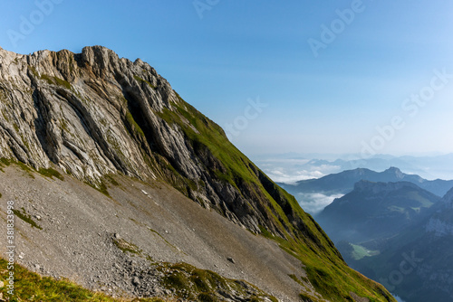 The Alpstein mountain range in Appenzell, Switzerland with the fog in the valley and the view of the Seealpsee lake