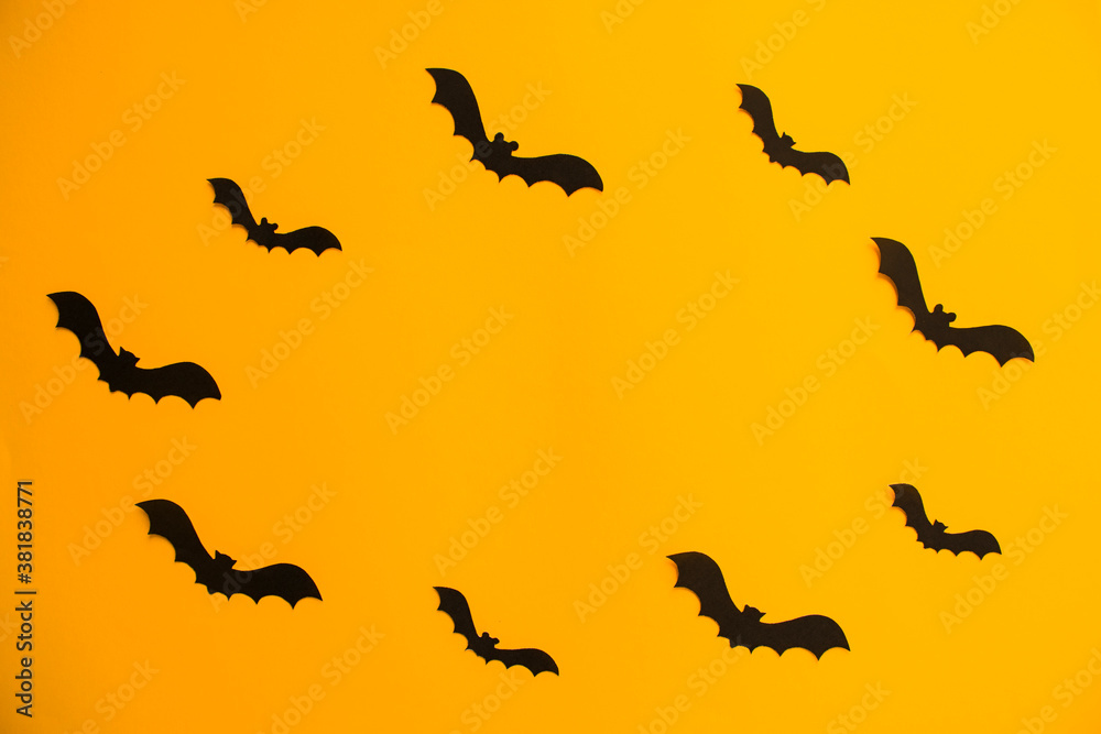 Frame of paper silhouettes of bats on orange background. Treat or trick Halloween holiday banner template with copy space in the middle. Frame of paper silhouettes of bats on orange background. Treat or trick Halloween holiday banner template with copy space in the middle.