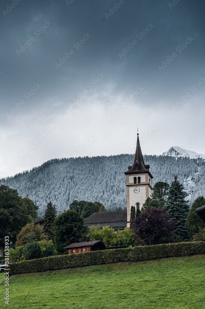 church of Grindelwald in autumn with first snow on the mountains