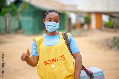image of african lady in face mask with thumbs up-child vaccination concept