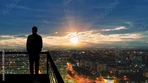 The man stands on the balcony on the cityscape background. hyperlapse