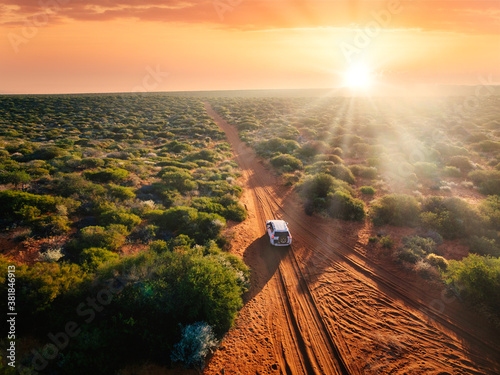 Australia, red sand unpaved road and 4x4 at sunset, freedom outback