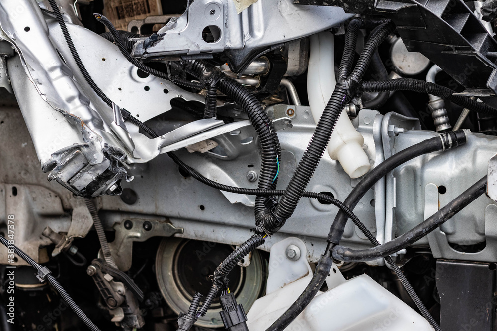 Obraz premium Close up shot of the remains of a wrecked vehicle after a serious car crash. Aftermath of drinking under influence, bent metal parts, smashed structure, ripped wires. Transport insurance concept.