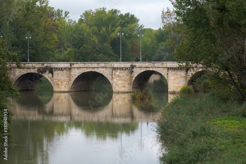 ashlar stone medieval bridge, puente mayor, crossing rio carrion, in autumn. Palencia, Spain.