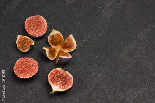 Fig fruits on wooden background. Fig halves, quarters and whole fruits.