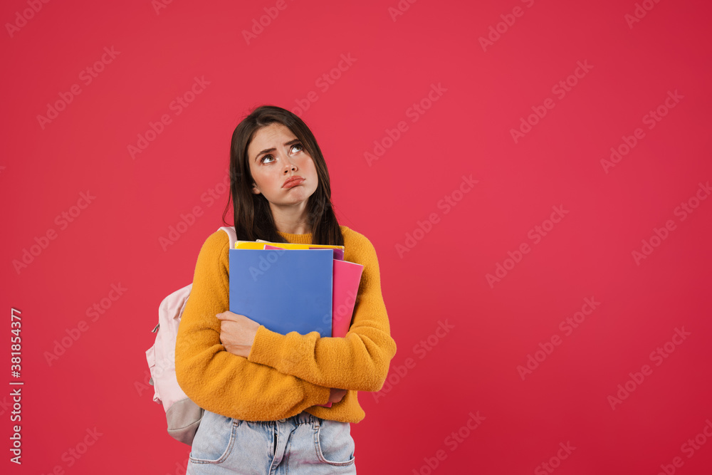 Image of unhappy beautiful student girl posing with exercise books