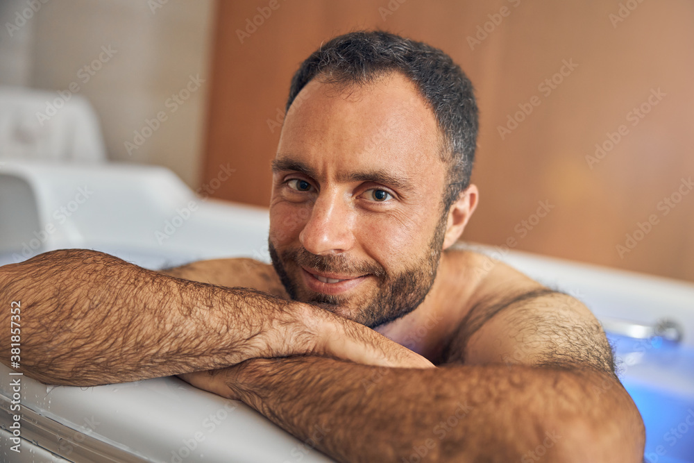 Obraz premium Handsome young man with stubble relaxing in bathtub