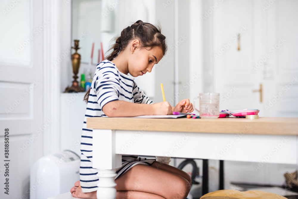 Little girl studying alone making notes, children elementary education concept. Cute smart primary school child girl learning writing doing homework sit at home table. Little girl studying alone making notes, children elementary education concept. Cute smart primary school child girl learning writing doing homework sit at home table.