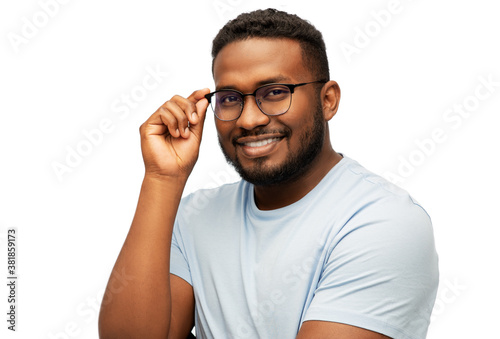 people, grooming and beauty concept - portrait of happy smiling young african american man in glasses over white background