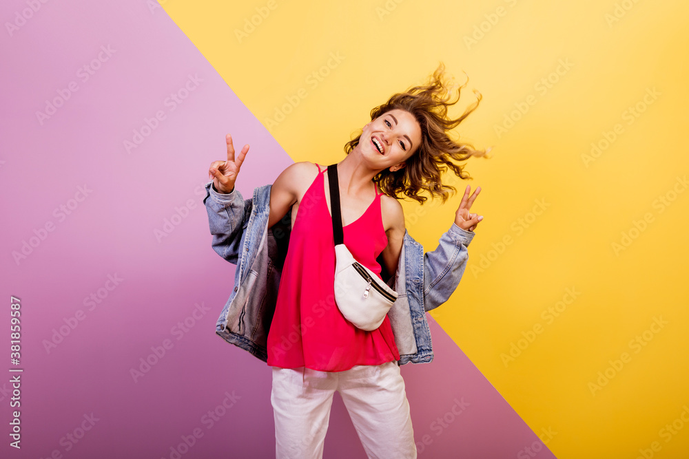 Funny woman with short wavy hairs dancing and having fun on multicolor background. Copy space for text. Funny woman with short wavy hairs dancing and having fun on multicolor background. Copy space for text.