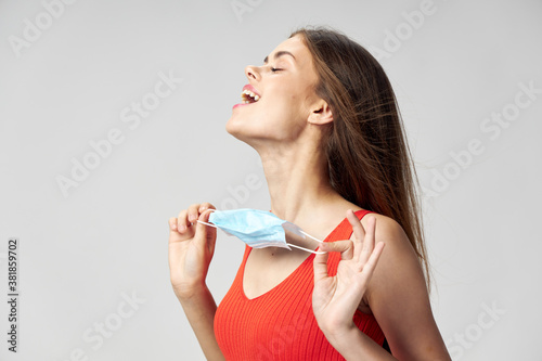 Woman holding a medical mask with closed eyes emotions