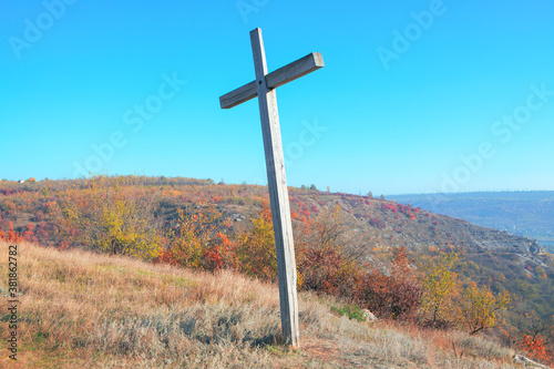 Autumn scenery with wooden cross on the hill