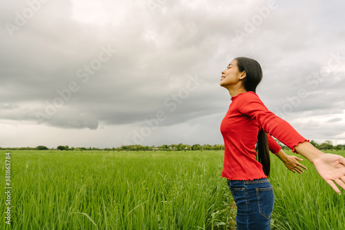 Happy Asian woman open arms stay on rice fields feeling happy in nature. © makibestphoto