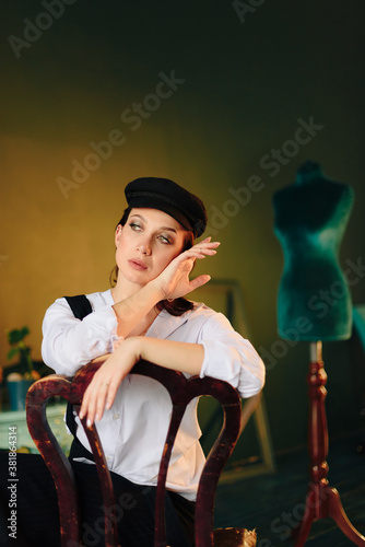 Portrait of a beautiful young woman in a white shirt and black trousers at home