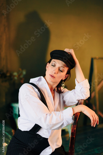 Portrait of a beautiful young woman in a white shirt and black trousers at home