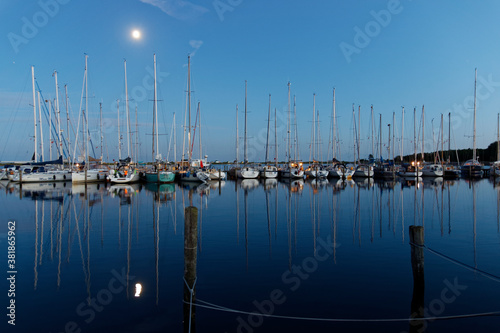 Hafenszene mit Segelbooten im Mondlicht, Silhouetten und Mond spiegeln im ruhigen Wasser © Joachim
