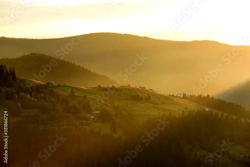View of the green mountains in the early morning. rays of light illuminating valleys and hills. Soft selective focus.