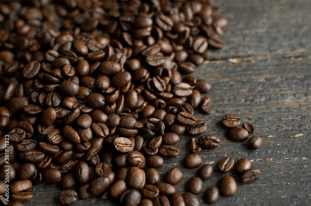 Roasted arabica coffee beans scattered on a wooden table. Fresh coffee beans. Roasted arabica coffee beans scattered on a wooden table. Fresh coffee beans.