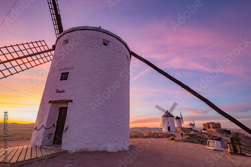 Beautiful white spanish windmill on the hill at fairy blue pink gold sunset near the castle in Consuegra, Toledo province, Spain