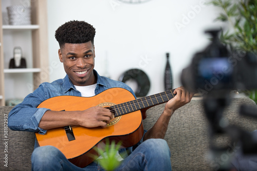 handsome man making video blog about musical instruments