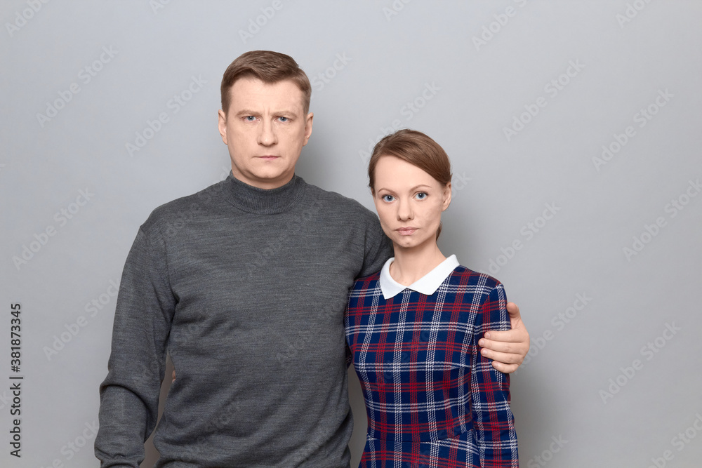 Portrait of serious man and woman hugging each other Portrait of serious man and woman hugging each other