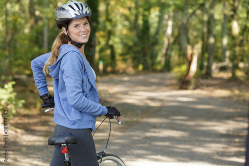 Fototapeta Naklejka Na Ścianę i Meble -  young happy female cyclist riding a bike