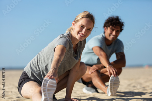 couple stretching on beach together