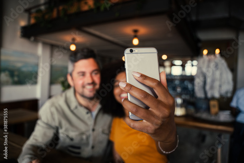 Cute couple in action taking selfie enjoying time in funky coffee shop