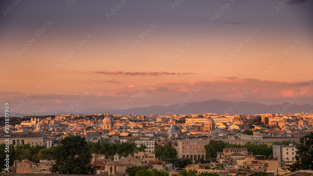 Beautiful skyline view of Roma from the Gianicolo hill at the sunset. Panorama of Rome from the above Colorful sky with orange clouds over the ancient monuments of the Italian Capital. Europe postcard