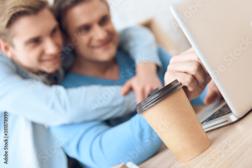 Father is working on laptop  drinking fresh coffee