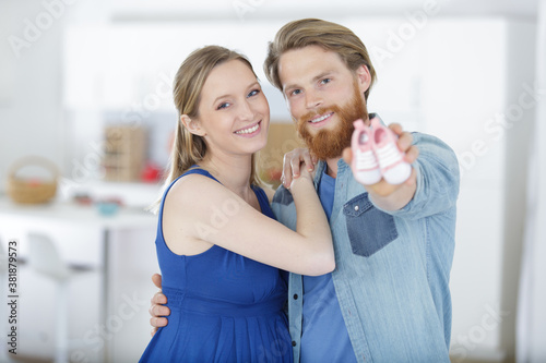 couple with tiny footwear on hands