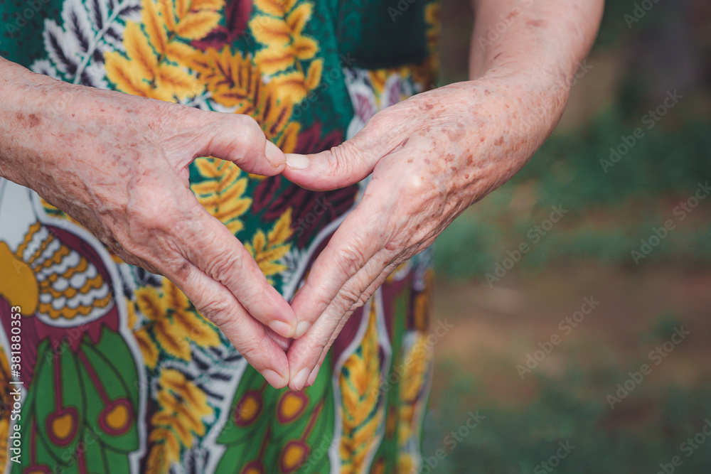 Close-up of hands senior woman showing making a heart shape with her hands and fingers. Concept of old people and love Close-up of hands senior woman showing making a heart shape with her hands and fingers. Concept of old people and love