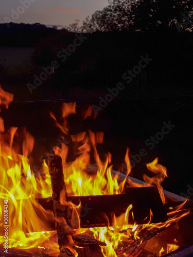 Selective focus shot of bonfire with sparks flying around in the darkness