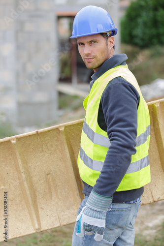 Photo carpenter woodworker labourer builder carries wooden board