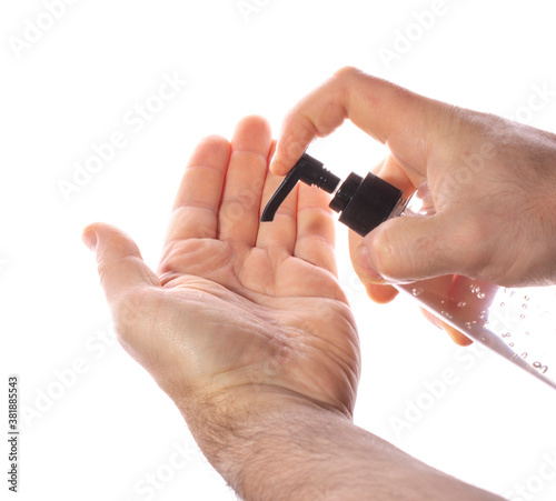 a man squeezes antiseptic gel from a transparent plastic bottle onto his hands on a white background. concept of counteracting the virus, clean hands.