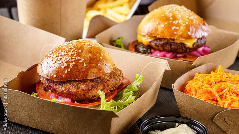Street food. Meat cutlet burgers are in paper boxes. Food delivery. Photos  | Adobe Stock