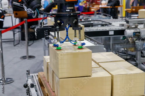 Konstfotografi View of vacuum gripper on robot lifting the box.