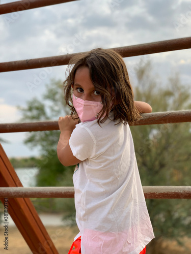 Girl with mask playing on some wooden bars