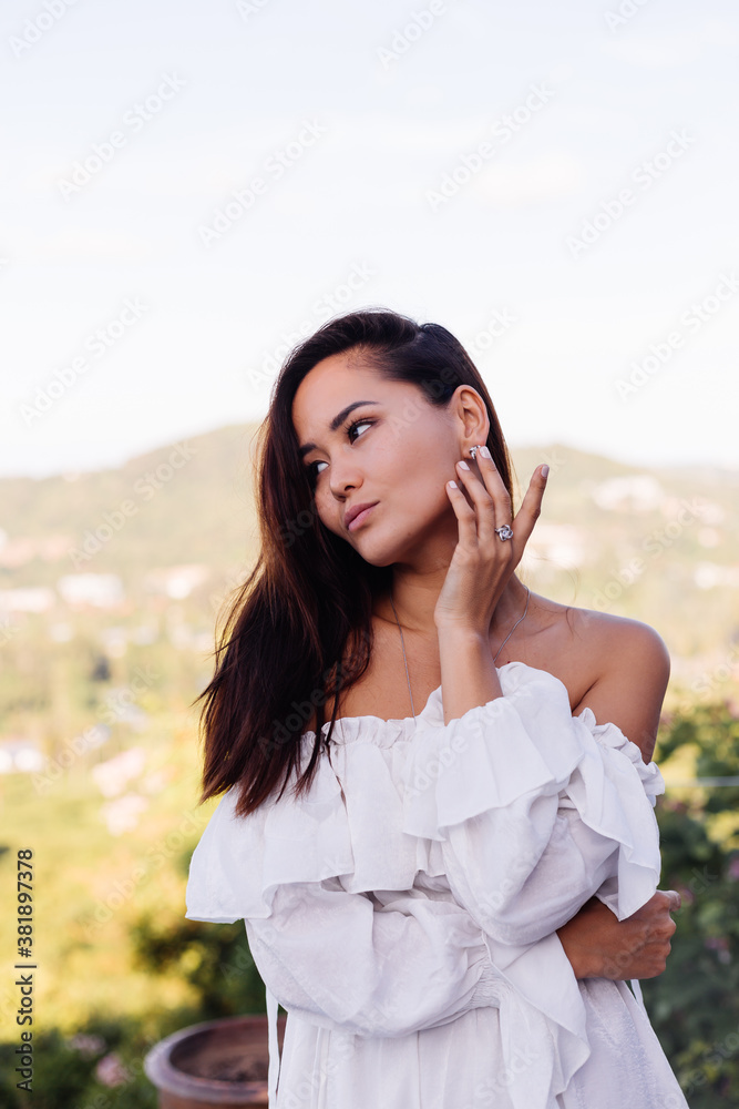 Outdoor portrait of asian woman in dress wearing necklace, earings and ring. Outdoor portrait of asian woman in dress wearing necklace, earings and ring.